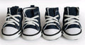 Four pairs of navy blue and white high-top sneakers on a white background. Bishop X 