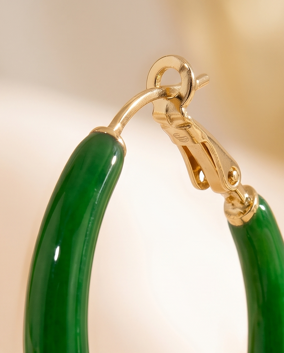 Gold and green hoop earring on a beige background. Bishop X 