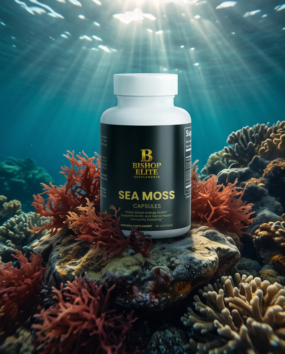 A white bottle of Bishop Elite Sea Moss Capsules stands on a rocky coral reef under ocean water with sunbeams filtering through the surface. The bottle has a black label with gold lettering. Bishop Elite Supplements 