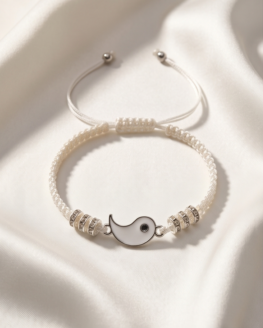 Silver bracelet with a moon charm on a white fabric background.  Bishop x 